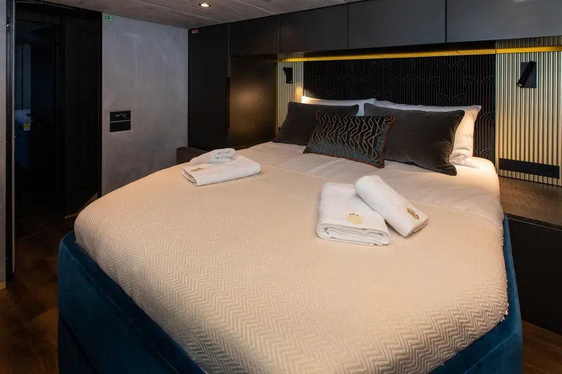 Mr. Si Yacht Photos Pics Luxurious bedroom interior of 2023 Sunreef 60 Sail yacht with elegant bedding and decor.