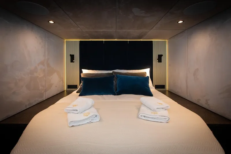 Mr. Si Yacht Photos Pics Luxurious bedroom interior of 2023 Sunreef 60 Sail yacht with elegant bedding and ambient lighting.