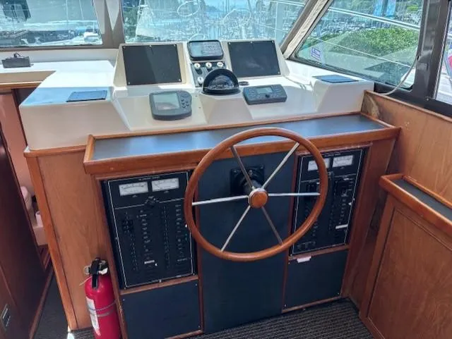 Thunderbolt Yacht Photos Pics 1988 Riviera Convertible boat helm with wooden steering wheel and navigation instruments.