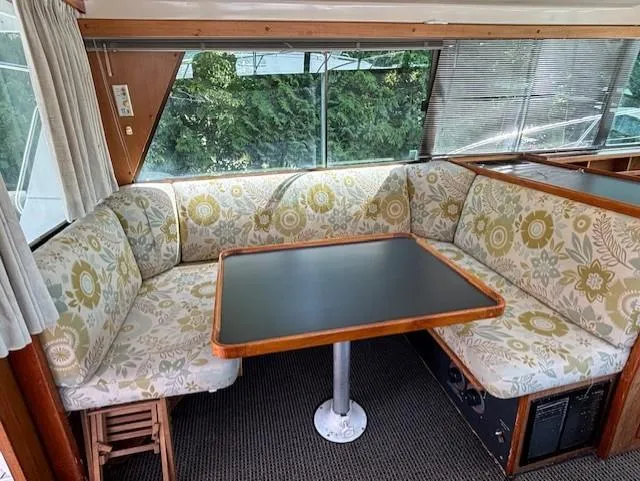 Thunderbolt Yacht Photos Pics 1988 Riviera Convertible interior with floral-patterned seating and a wooden table.