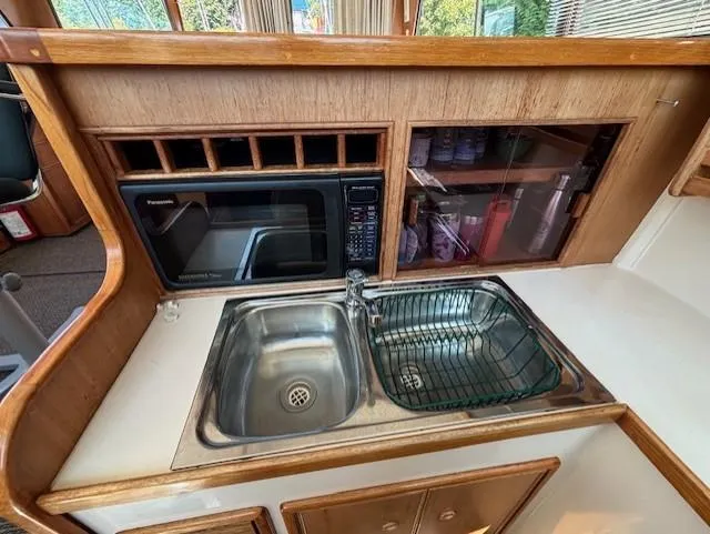 Thunderbolt Yacht Photos Pics 1988 Riviera Convertible kitchen with sink, microwave, and storage cabinets.