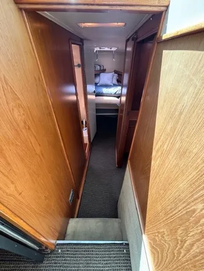 Thunderbolt Yacht Photos Pics 1988 Riviera Convertible interior hallway leading to cozy bedroom with wooden paneling.
