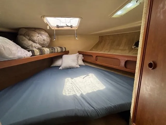 Thunderbolt Yacht Photos Pics Cozy cabin interior of 1988 Riviera Convertible boat with bedding and porthole.