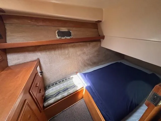 Thunderbolt Yacht Photos Pics 1988 Riviera Convertible cabin interior with bed, wooden cabinetry, and small window.