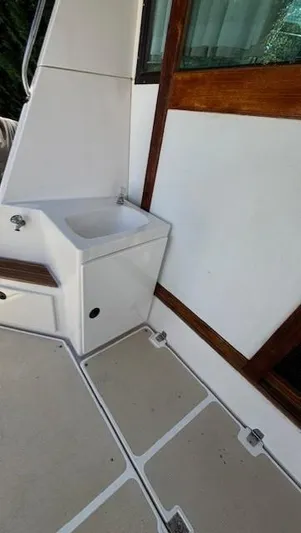 Thunderbolt Yacht Photos Pics 1988 Riviera Convertible boat interior with sink and wooden accents.
