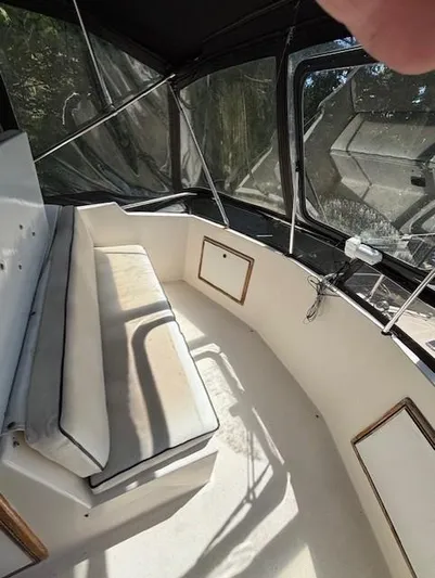 Thunderbolt Yacht Photos Pics 1988 Riviera Convertible boat interior with cushioned seating and large windows.