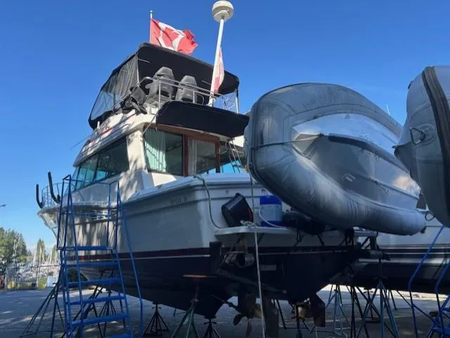 Thunderbolt Yacht Photos Pics 1988 Riviera Convertible boat on stands with inflatable dinghy, Canadian flag, clear blue sky.