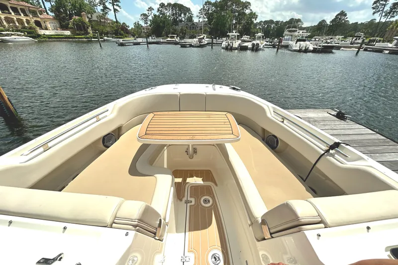  Yacht Photos Pics 2017 Boston Whaler 320 Vantage boat interior with seating and table, docked by a marina.
