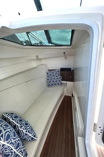  Yacht Photos Pics 2017 Boston Whaler 320 Vantage cabin interior with cushions and wooden flooring.