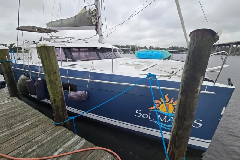 Sol Mates Yacht Photos Pics 2018 Fountaine Pajot SABA 50 catamaran docked, featuring blue hull and sun logo.