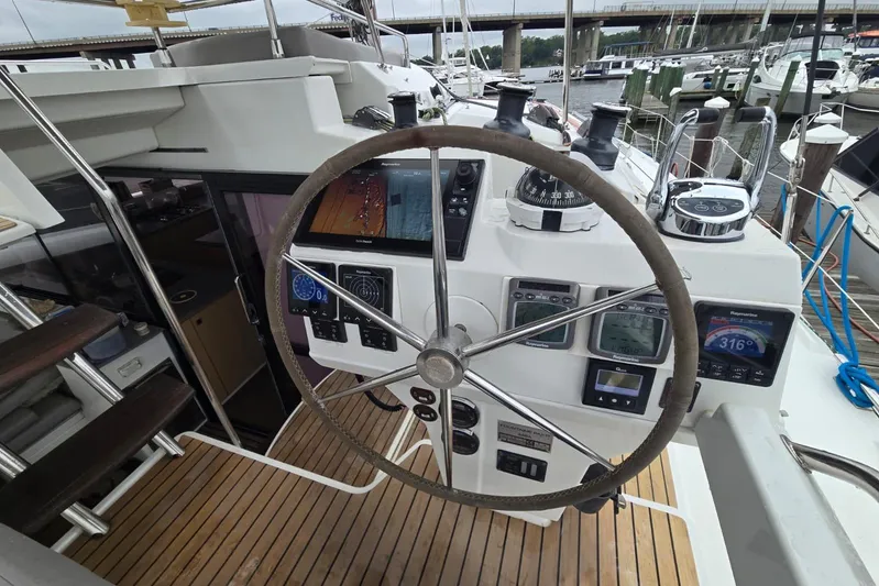 Sol Mates Yacht Photos Pics Helm of 2018 Fountaine Pajot SABA 50 catamaran with navigation instruments and wooden deck.
