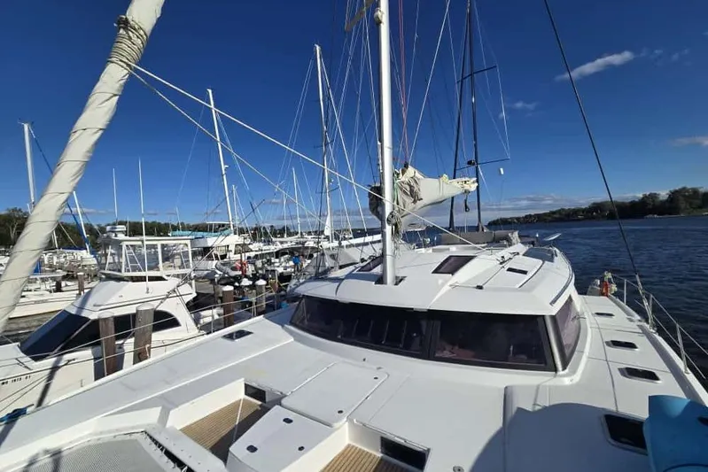 Sol Mates Yacht Photos Pics 2018 Fountaine Pajot SABA 50 catamaran docked at a marina under clear blue skies.