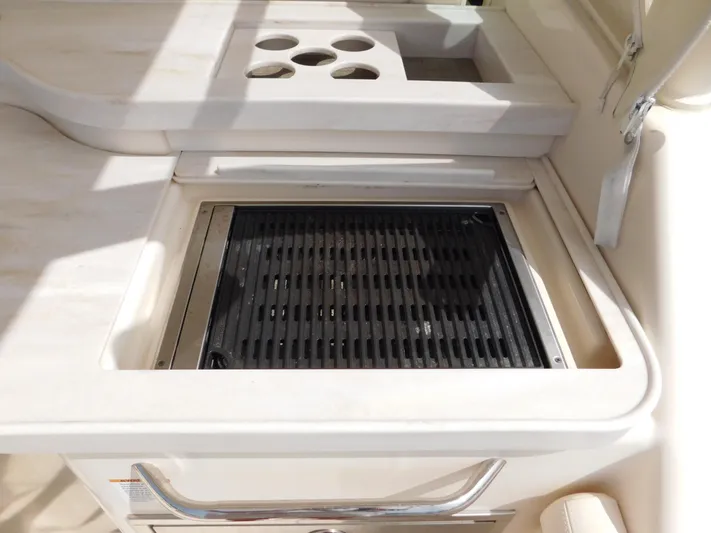 Here & Now Yacht Photos Pics Built-in grill on 2018 Grady-White Freedom 375 boat, featuring cup holders and sleek design.