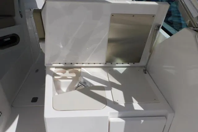  Yacht Photos Pics 2016 Pursuit DC 325 Dual Console boat interior with open storage compartment and cup holders.