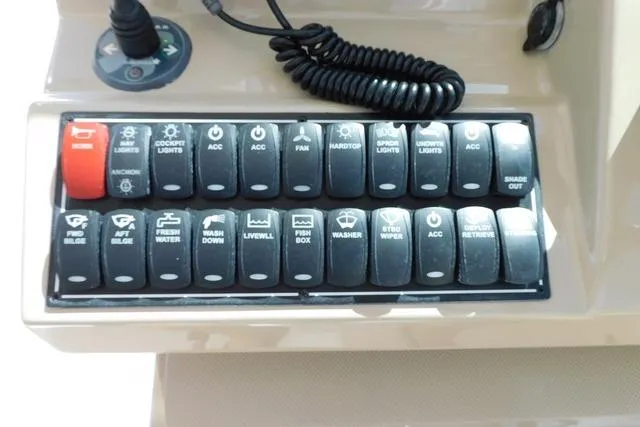  Yacht Photos Pics Control panel of a 2016 Pursuit DC 325 Dual Console boat with labeled switches.