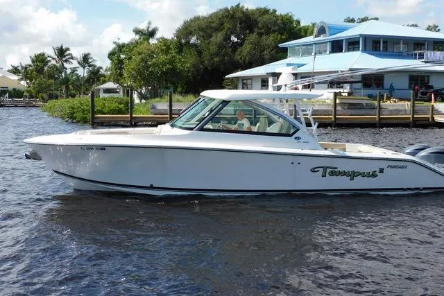  Yacht Photos Pics 2016 Pursuit DC 325 Dual Console boat on water near dockside buildings.