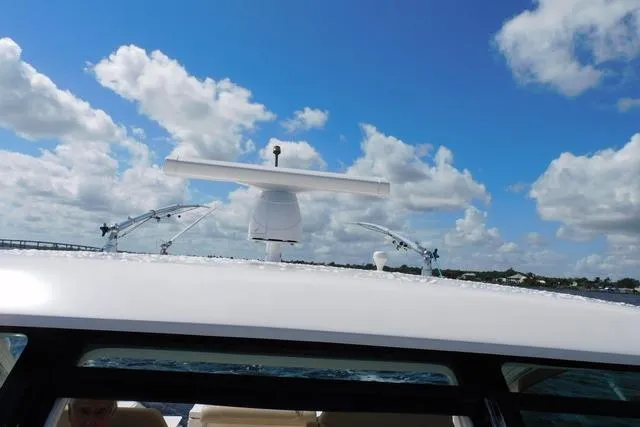  Yacht Photos Pics 2016 Pursuit DC 325 Dual Console boat on water under blue sky with clouds.
