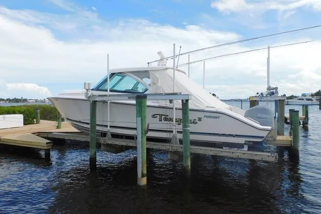  Yacht Photos Pics 2016 Pursuit DC 325 Dual Console boat docked on a lift by the water.