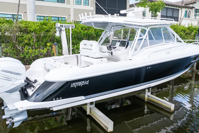  Yacht Photos Pics 2023 Intrepid 345 Valor boat with Mercury engines docked near waterfront homes.