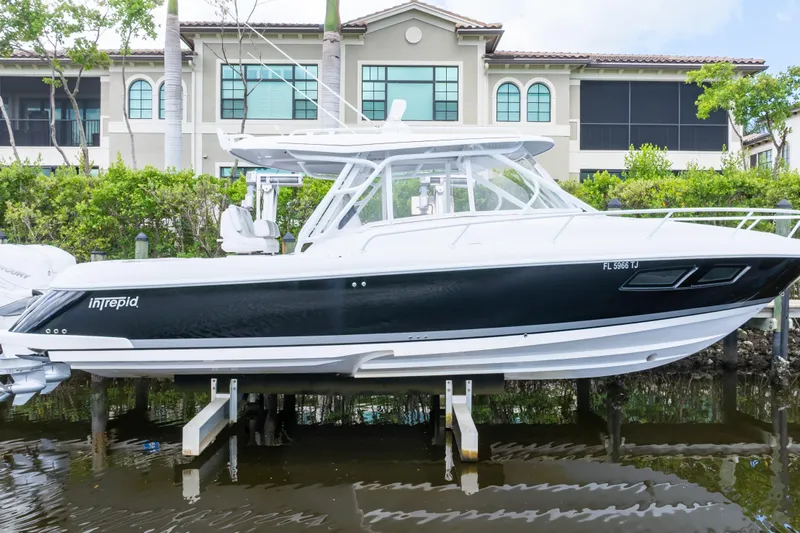  Yacht Photos Pics 2023 Intrepid 345 Valor boat docked near waterfront property.