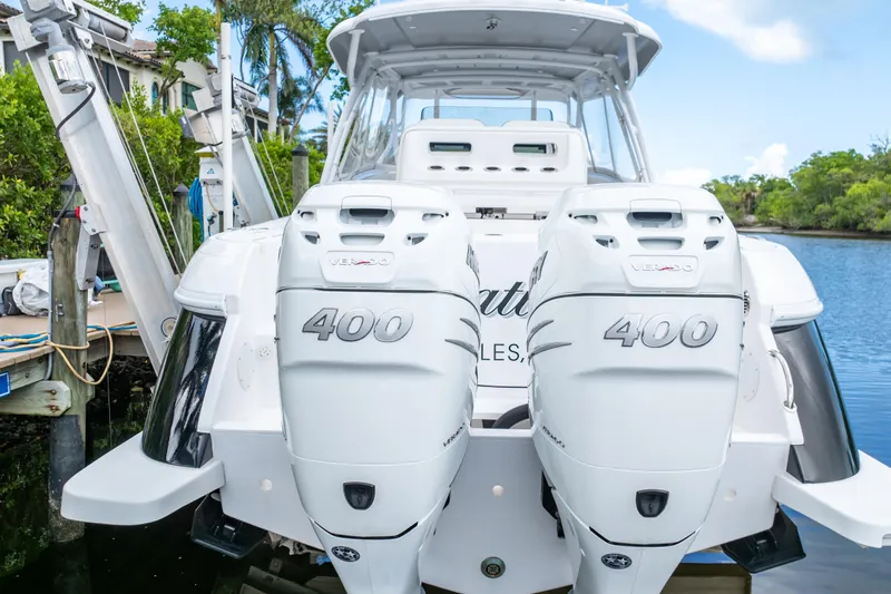 Yacht Photos Pics 2023 Intrepid 345 Valor boat with dual 400 horsepower engines docked by lush greenery.