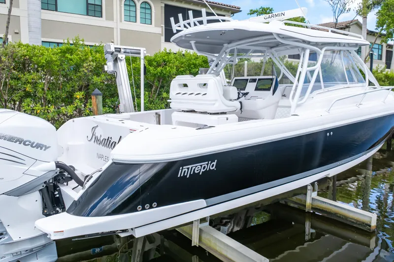  Yacht Photos Pics 2023 Intrepid 345 Valor boat with Mercury engines, docked near luxury homes.