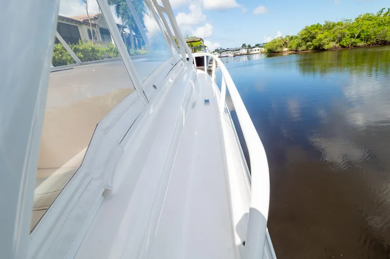  Yacht Photos Pics 2023 Intrepid 345 Valor boat cruising on a calm river under a clear sky.
