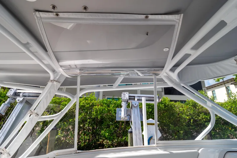 Yacht Photos Pics 2023 Intrepid 345 Valor boat canopy and frame detail with lush greenery background.