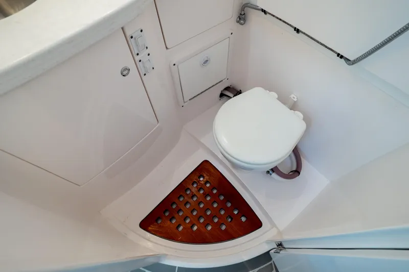  Yacht Photos Pics 2023 Intrepid 345 Valor boat bathroom with white toilet and wooden floor mat.