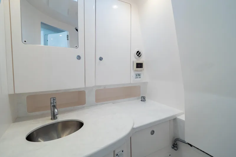  Yacht Photos Pics 2023 Intrepid 345 Valor boat bathroom with sleek white cabinetry and modern sink.