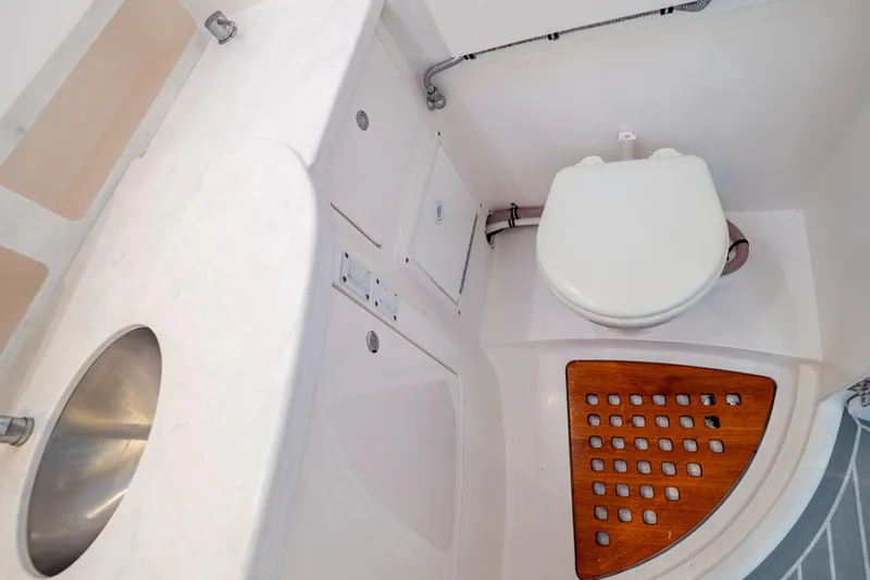  Yacht Photos Pics 2023 Intrepid 345 Valor boat bathroom with sink, toilet, and wooden floor panel.