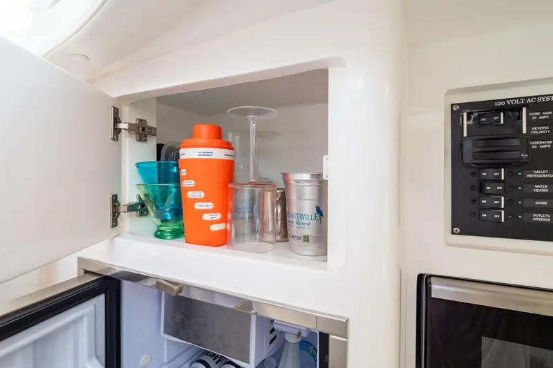  Yacht Photos Pics 2023 Intrepid 345 Valor interior cabinet with glasses and drinkware.