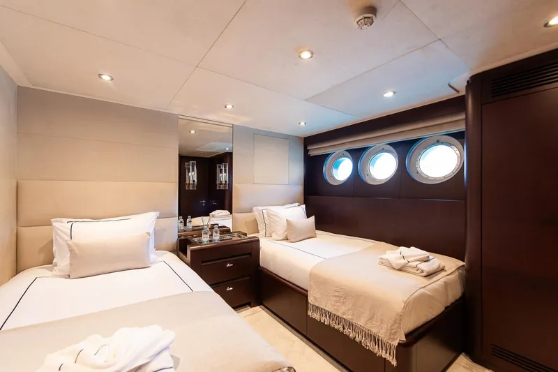 Koru Yacht Photos Pics Luxurious twin cabin on 1983 Feadship Custom yacht with porthole windows and elegant decor.
