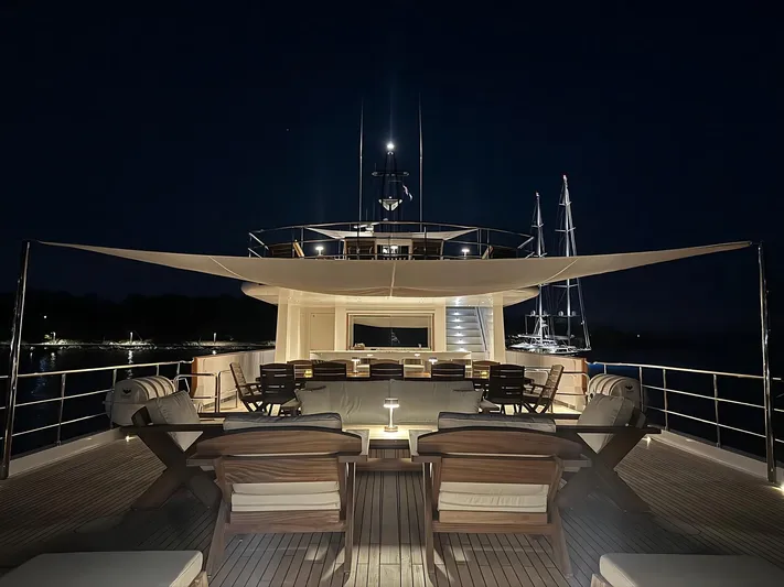 Koru Yacht Photos Pics Luxurious 1983 Feadship Custom yacht deck at night, featuring elegant seating and ambient lighting.