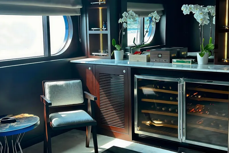 Koru Yacht Photos Pics Luxurious yacht interior with wine cooler, elegant chair, and decorative orchids, Feadship Custom 1983.