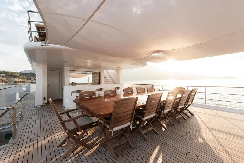 Koru Yacht Photos Pics Luxurious 1983 Feadship Custom yacht deck with elegant dining area at sunset.