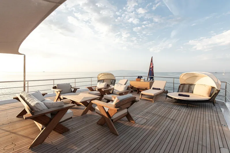 Koru Yacht Photos Pics Luxurious deck of 1983 Feadship Custom yacht with elegant wooden furniture and ocean view.