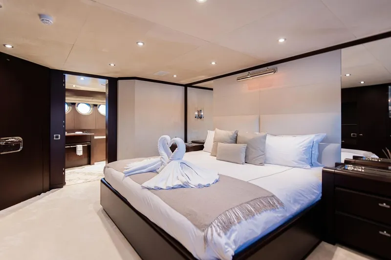 Koru Yacht Photos Pics Luxurious bedroom on 1983 Feadship Custom yacht with elegant decor and swan towel art.
