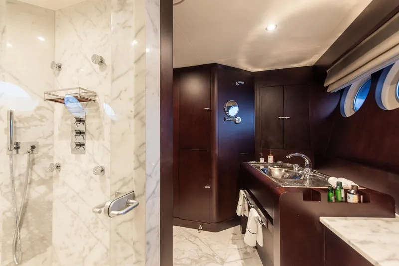 Koru Yacht Photos Pics Luxurious yacht bathroom with marble shower and dark wood accents, Feadship Custom 1983.
