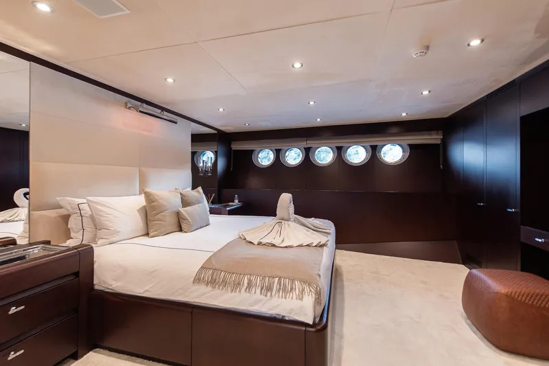 Koru Yacht Photos Pics Luxurious bedroom interior on 1983 Feadship Custom yacht with elegant decor and porthole windows.