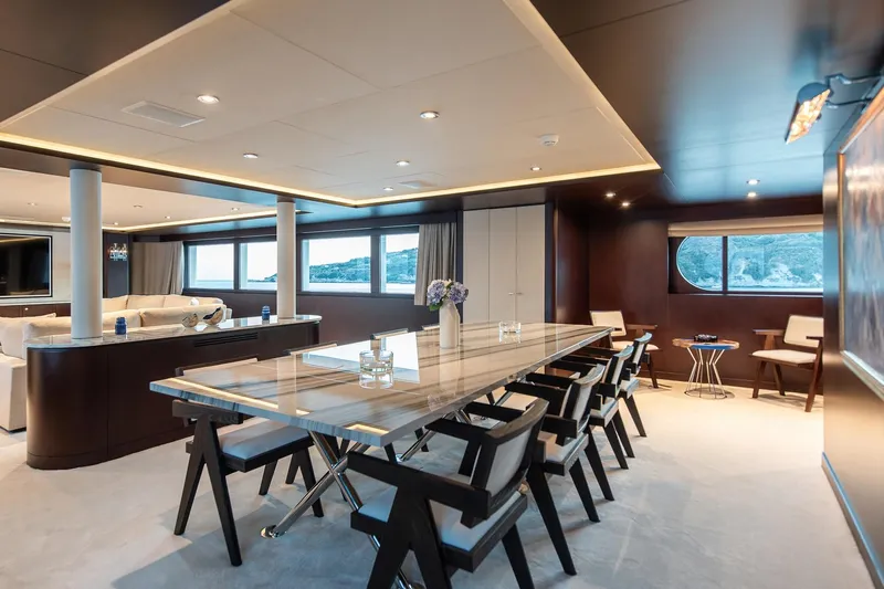 Koru Yacht Photos Pics Luxurious dining area on 1983 Feadship Custom yacht with elegant furnishings and large windows.