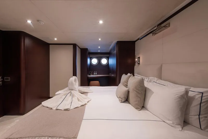 Koru Yacht Photos Pics Luxurious bedroom on 1983 Feadship Custom yacht with elegant decor and plush bedding.
