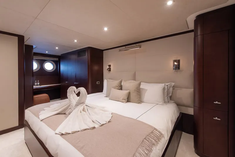 Koru Yacht Photos Pics Luxurious yacht bedroom with elegant decor, featuring swan towel art on the bed.