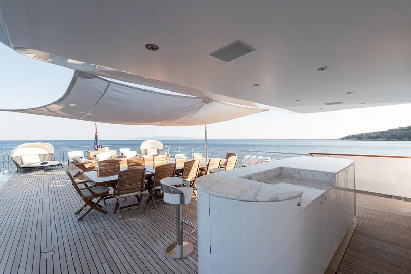 Koru Yacht Photos Pics Luxurious 1983 Feadship Custom yacht deck with dining area and ocean view.