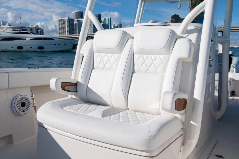In Stock Yacht Photos Pics Luxurious white seating on a 2026 Jupiter 32 boat, with yachts and city skyline in the background.