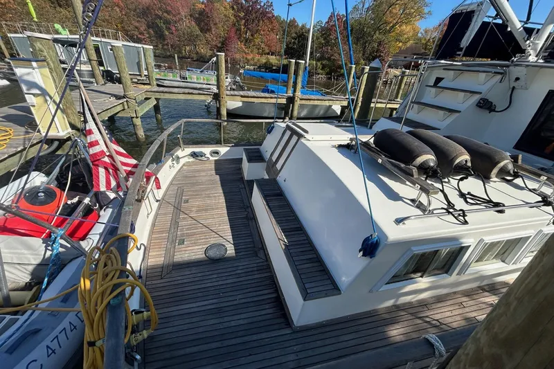 Radius Yacht Photos Pics 1986 Grand Banks 42 Classic yacht docked, featuring wooden deck and American flag.