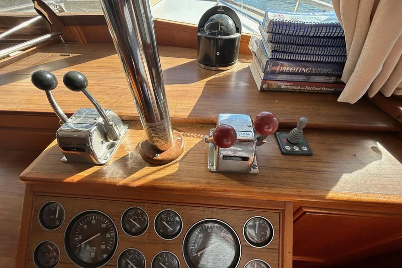 Radius Yacht Photos Pics 1986 Grand Banks 42 Classic helm with controls, gauges, and navigation books.