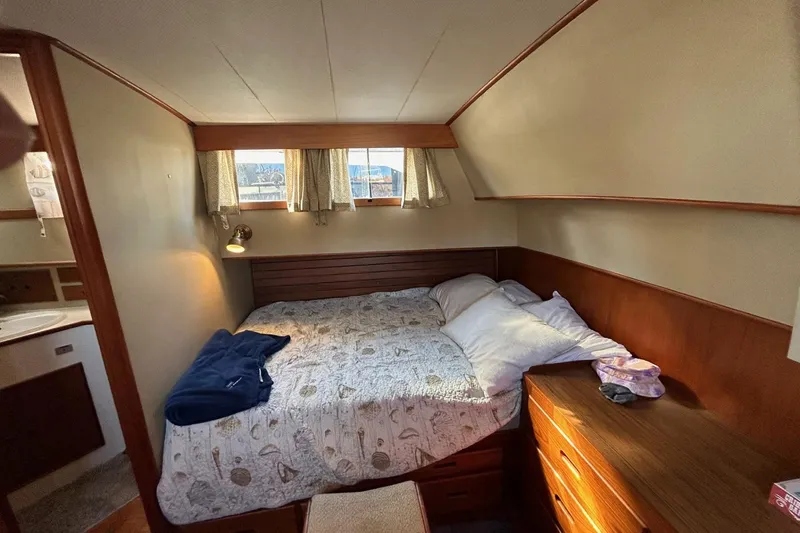 Radius Yacht Photos Pics Cozy bedroom interior of 1986 Grand Banks 42 Classic yacht with bed and wooden furnishings.
