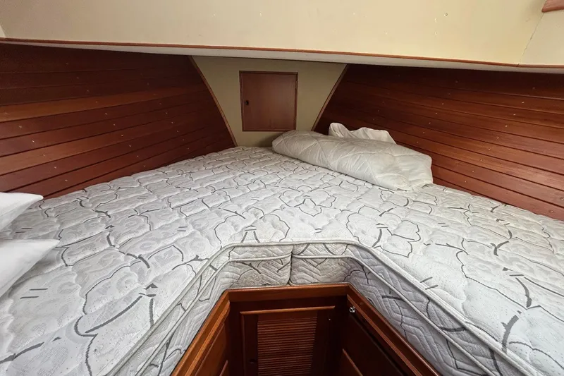 Radius Yacht Photos Pics Cozy cabin interior of 1986 Grand Banks 42 Classic with wooden paneling and patterned bedding.