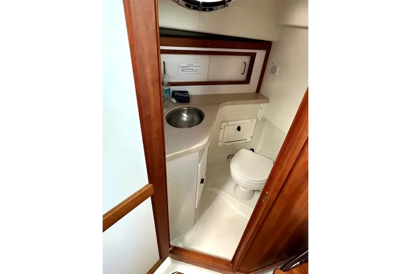  Yacht Photos Pics 2007 Back Cove 29 boat bathroom with sink, toilet, and wooden cabinetry.